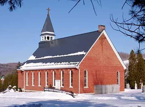 Brick church roof in winter maintained by commercial roofing St Louis contractors